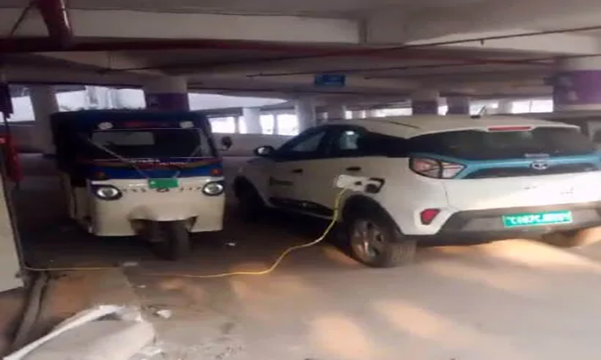 Employees charge electric cars in multilevel parking
